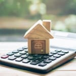 A small model of a house on a calculator.